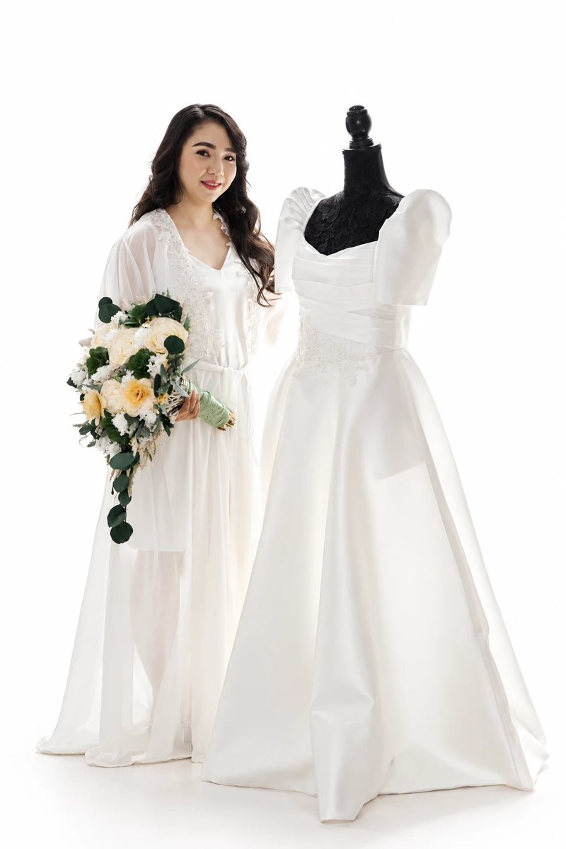 A bride with her finished hair and makeup, holding her bouquet beside her gown