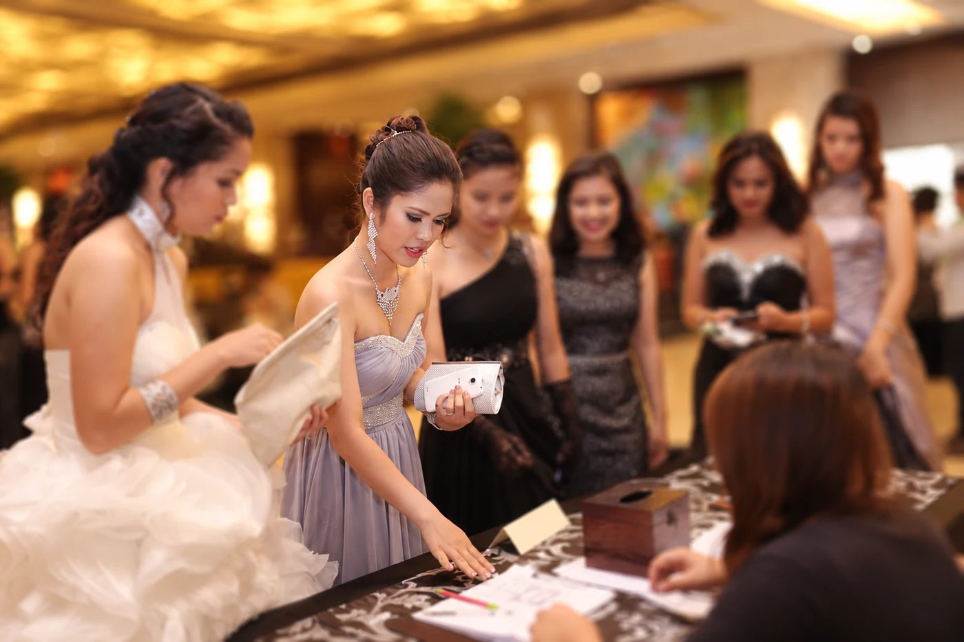 Guests in evening gowns with full glam makeup at a formal event